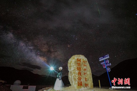 圖為6月20日晚，游客“打卡”西藏阿里暗夜公園，天上是銀河與流星（右上角）。曹枝清 攝