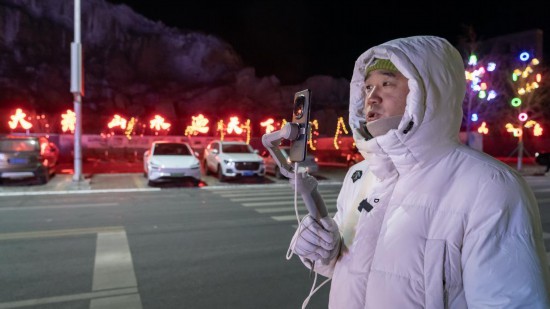 在吉林市阿什哈達(dá)霧凇觀景帶，霧凇播報(bào)員正在直播。新華社記者 李典 攝