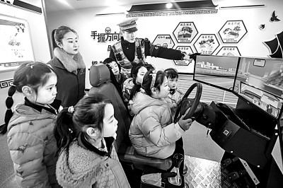 山東省榮成市公安局道路交通安全宣傳教育基地,交警帶領(lǐng)小學生現(xiàn)場體驗模擬駕駛。新華社發(fā)