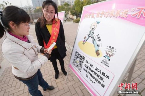 資料圖:今年3月8日,安徽合肥新華社區(qū)志愿者夏一瓊(右)向市民普及反家暴相關法律知識。鐘欣 攝